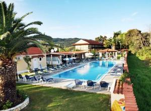 a swimming pool with lounge chairs and a resort at Elleana south Corfu in Agios Georgios
