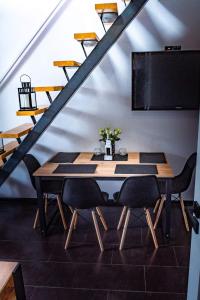 comedor con mesa con sillas y TV de pantalla plana en Rivendell Mielno en Mielno