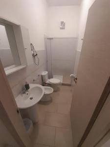 a white bathroom with a sink and a toilet at CTA Catania Aeroporto fontanarossa reception h24 in Catania