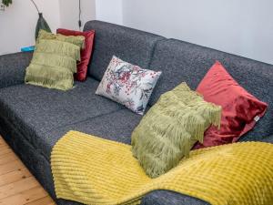 a couch with several pillows on it at JUNIK Apartments Oberhausen in Oberhausen