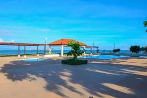 a pavilion with a tree in the middle of a beach at Impeccable 2-Br Apartment-Ornella Villa in Portmore