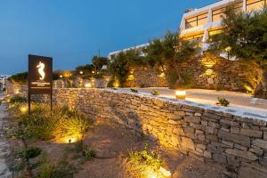 a stone wall with a sign in front of a building at Hippocampus Hotel in Naousa