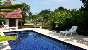 uma piscina com duas cadeiras ao lado de uma casa em Sunflower Villas em Ko Chang