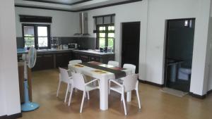 uma cozinha com uma mesa branca e cadeiras brancas em Sunflower Villas em Ko Chang