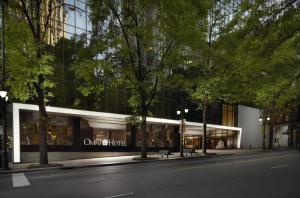 un bâtiment situé dans une rue avec des arbres devant elle dans l'établissement Omni Charlotte Hotel, à Charlotte