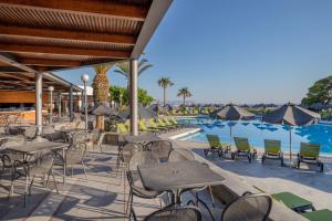 a patio with tables and chairs next to a swimming pool at Sol Marina Beach Crete in Gouves
