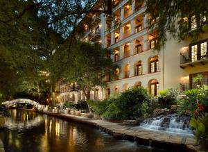 a building with a river in front of a building at Omni La Mansion del Rio in San Antonio