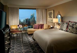 a hotel room with a bed and a couch and a window at Omni Nashville Hotel in Nashville