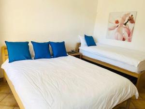 1 Schlafzimmer mit 2 Betten und blauen Kissen in der Unterkunft Princess Palace Beach Monte-Carlo in Monte Carlo