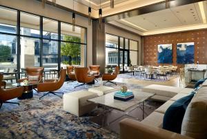 a lobby with couches and tables and windows at Omni Frisco at The Star in Frisco