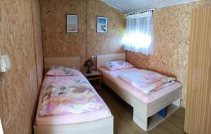 a small room with two beds and a window at SŁONECZNIK domki letniskowe Charbrowo-Łeba in Charbrowo