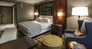 a hotel room with a bed and a chair at Omni Louisville Hotel in Louisville