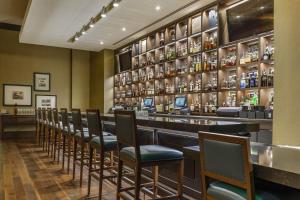 a bar with a row of chairs in a room at Omni Louisville Hotel in Louisville