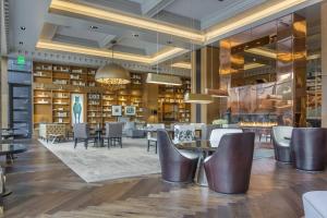 a lobby with tables and chairs and a library at Omni Louisville Hotel in Louisville