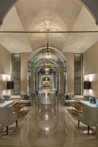 a lobby with tables and chairs and a chandelier at Omni Louisville Hotel in Louisville +37 photos