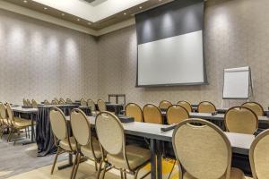 a conference room with tables and chairs and a screen at Omni Louisville Hotel in Louisville