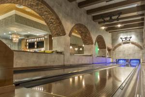 an empty bowling alley with blue lights on the lanes at Omni Louisville Hotel in Louisville