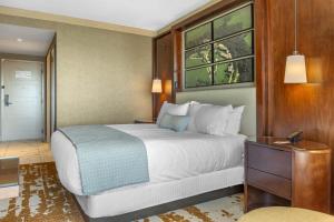 a bedroom with a large white bed and a wooden wall at Omni Louisville Hotel in Louisville