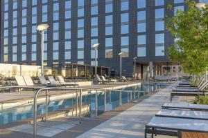 a hotel swimming pool with lounge chairs in front of a building at Omni Louisville Hotel in Louisville