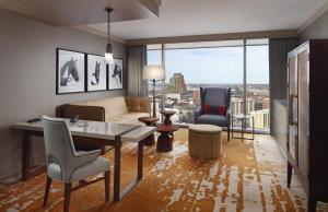 a living room with a couch and a table and chairs at Omni Louisville Hotel in Louisville