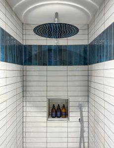a bathroom with a shower with blue and white tiles at Parador 44 in Cardiff