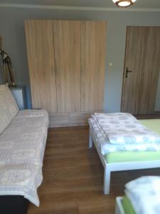 a bedroom with two beds and wooden cabinets at Pokoje Gdynia Demptowo in Gdynia