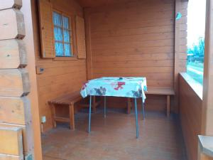 a room with a table and a bench in a cabin at Chatka Rozárka - Výrovická přehrada in Horní Dunajovice
