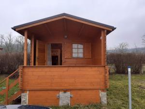 a small wooden house in a field at Chatka Rozárka - Výrovická přehrada in Horní Dunajovice