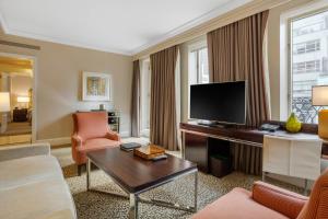 a living room with a couch and a television at Omni Berkshire Place in New York +138 photos