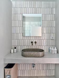 W łazience znajduje się umywalka i lustro. w obiekcie Siora of Paros - Ammiralis & Castelis w mieście Nausa