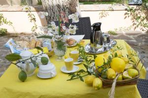 a table with a yellow table cloth with fruit on it at All'Ombra Del Noce B&B in Catona