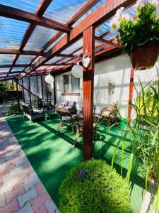 a patio with a wooden pergola with a table and chairs at Dom Gościnny Kinga in Pobierowo