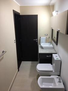 Łazienka z białą toaletą i umywalką w obiekcie LA CASA DEL LAGO TANDIL w mieście Tandil