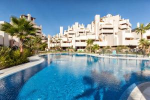 een groot zwembad voor sommige gebouwen bij Fantástico apartamento en primera línea de playa in Estepona