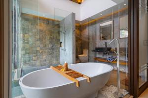a bathroom with a large tub and a shower at Lalasa Villas Canggu in Canggu