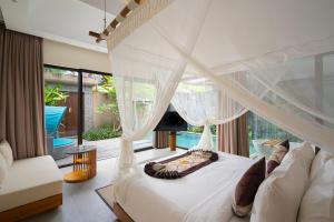 a bedroom with a white bed with a canopy at Lalasa Villas Canggu in Canggu
