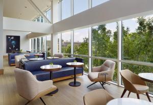 a lobby with a blue couch and tables and windows at Omni Atlanta Hotel at Centennial Park in Atlanta