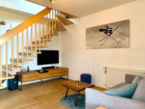 ein Wohnzimmer mit Sofa und Fernseher in der Unterkunft Alpenflair Ferienwohnung 231 Mina's Gipfelliebe in Oberstdorf