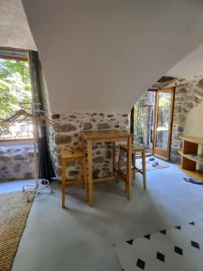 d'une salle à manger avec une table et une fenêtre. dans l'établissement Rendez-vous sous le tilleul, en Cevennes., à Molières-Cavaillac