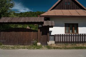a house with a wooden gate and a fence at Chalupa u Janov in Mýto pod Ďumbierom