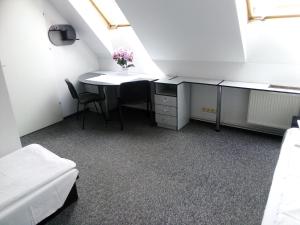 ジェシュフにあるHostel Wiarusのデスクとテーブル付きの屋根裏部屋
