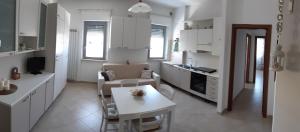 a kitchen with white cabinets and a table in a room at Little House in San Salvo