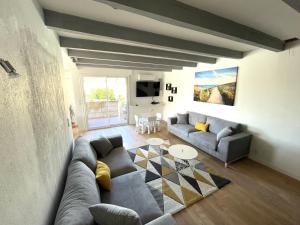 a living room with a couch and a table at L'Artmonie - Climatisé - Jardin - Centre-ville - Plage in Perpignan