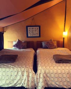ein Schlafzimmer mit 2 Betten und einem Bild an der Wand in der Unterkunft Sakara Gion in Kyoto