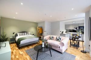 1 dormitorio con cama, sofá y mesa en Dragon Suites Luxury Serviced Apartments at Alva Street en Edimburgo