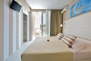 A bed or beds in a room at Sidari Beach Hotel