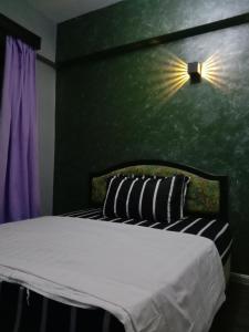 GLORY Beach Resort private 2 bedroom apartment في بورت ديكسون: غرفة نوم بسرير مع جدار أخضر