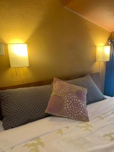 a bed with two pillows on it with two lamps at Sakara Gion in Kyoto