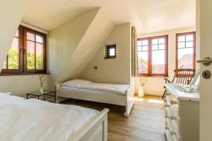 1 dormitorio con 1 cama y una escalera con ventanas en Nele Nelsson Hus, Landhaus Haven Höövt, en Ahrenshoop