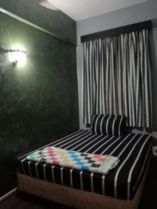 1 dormitorio con 1 cama con pared negra en GLORY Beach Resort private 2 bedroom apartment en Port Dickson